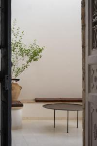 a table and a vase with a plant in a room at Khan Ein Karem Boutique Hotel in Jerusalem