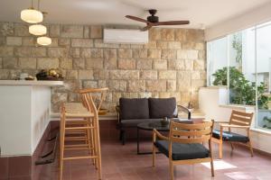 a living room with a couch and a ceiling fan at Khan Ein Karem Boutique Hotel in Jerusalem