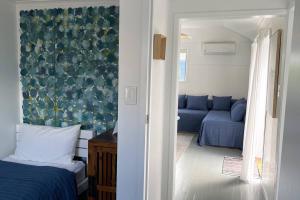 a bedroom with a blue bed and a couch at Breezy Blue on Bribie in Bongaree