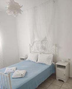 una camera con letto blu e testiera bianca di ONAR STUDIOS MILOS ad Adámas