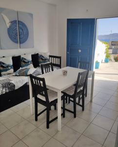 una sala da pranzo con tavolo, sedie e un letto di ONAR STUDIOS MILOS ad Adámas