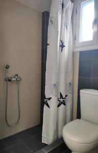 un bagno con tenda doccia con stelle di ONAR STUDIOS MILOS ad Adámas