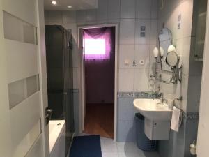 a bathroom with a sink and a shower and a window at Apartament Plaża z 2 sypialniami i salonem - 150 m od morza in Kołobrzeg