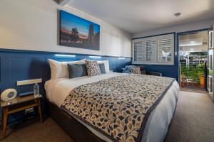 a hotel room with a large bed and a large window at Granite Belt Motel in Stanthorpe