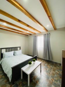 Villa Macrina في فالي دي جوادالوبي: غرفة نوم بسرير وطاولة فيها نباتين