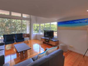 a living room with a couch and a flat screen tv at Maggies Beachfront Apartment 5 in Horseshoe Bay