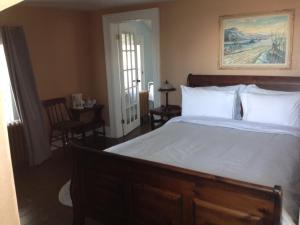ein Schlafzimmer mit einem großen Bett mit weißer Bettwäsche in der Unterkunft Stevenson Farms-Harvest Spa B & B in Alliston