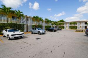 a parking lot with cars parked in front of buildings at OYO Hotel Coral Gables - Miami Airport in Miami