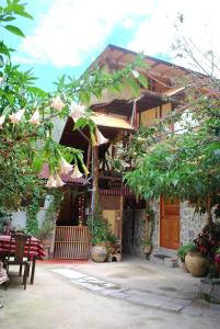 una casa con patio arredato con sedie e alberi di Kiswar Lodg a Ollantaytambo