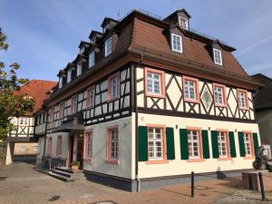 un edificio con entramado de madera y ventanas verdes y blancas en Wohnung 1- nur 5 min. zum Europapark, en Ettenheim
