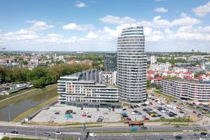 a tall building in a city with a parking lot at ONE Luxury Apartments in Rzeszów