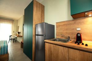 eine Küche mit einem Kühlschrank aus Edelstahl und einer Spüle in der Unterkunft Le Grand Rêve in Gerakini
