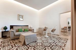 Palazzo San Lazzaro - Jacuzzi Rooms & Suites SIT في ليتشي: غرفة معيشة مع أريكة وطاولة
