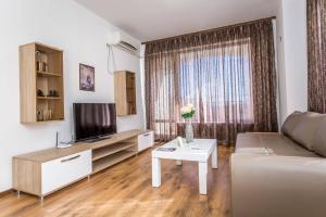 sala de estar con sofá y TV en Апартамент за гости Villa Ravda, en Ravda