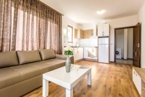 a living room with a couch and a table at Апартамент за гости Villa Ravda in Ravda