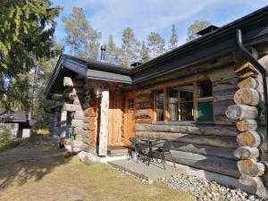 una cabaña de madera con una mesa y sillas frente a ella en Rantaruka Apartment, en Ruka