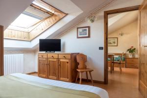 a bedroom with a bed and a television and a table at Hotel Cristallo in Bormio