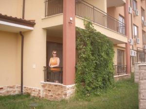 una mujer parada en un balcón de un edificio en Magic Dreams Apart Complex, studio, en Sveti Vlas
