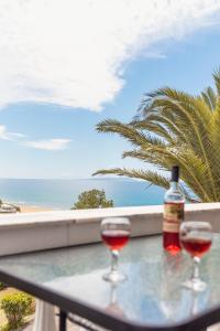 two glasses of wine on a table with a view of the ocean at Adriatica View in Vitalades