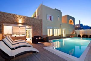 eine Villa mit einem Pool vor einem Haus in der Unterkunft Gianna Suites in Fira