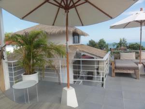 a patio with an umbrella and a table and chairs at High Life Bungalow in Haad Yao