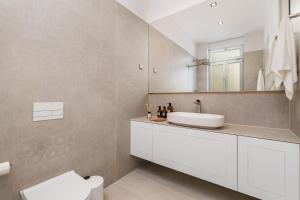 a bathroom with a white sink and a mirror at Plaza Apartments in Opatija