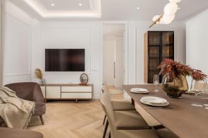 a dining room with a table and chairs and a television at Plaza Apartments in Opatija