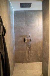 um chuveiro com uma mangueira na casa de banho em hygge Niederrhein em Rees