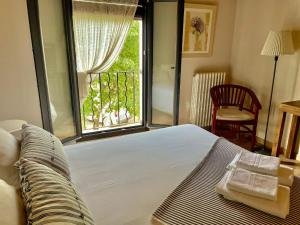 a bedroom with a bed and a large window at Laindustria in Palamós