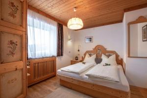 um quarto com uma cama com lençóis brancos e uma janela em Binterhof em Castelrotto