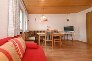 a living room with a table and a tv at Haus Valuga in Bürserberg