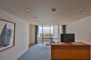 a living room with a television on a wooden cabinet at TOTO Seawind Awaji in Awaji