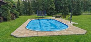 a swimming pool in a grassy yard with a picnic table at Leniwy Motyl in Rajcza