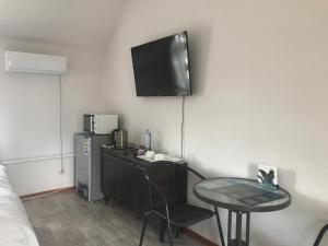 a room with a table and a television on the wall at Akbulak in Almaty