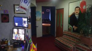 a living room with a painting of a man on the wall at CTH-Baku-Hostel in Baku