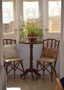 2 sillas y una mesa en una habitación con ventanas en Maria Townhouse Heart of Victoria B&B, en Victoria