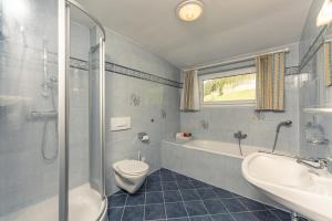 a bathroom with a toilet and a tub and a sink at Gästehaus Huber Frühstückspension in Schladming +43 photos