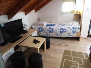um pequeno quarto com uma cama e uma televisão em Apartman 2 em Krapina