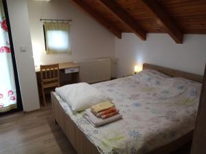 a bedroom with a bed with a table and a chair at Apartman 2 in Krapina