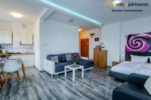 salon z kanapą, łóżkiem i stołem w obiekcie Baltic Apartments - Apartament Słoneczny Taras w Świnoujściu