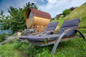 ein Paar Stühle und eine Holzbadewanne auf einem Hügel in der Unterkunft CASA DELLE API in Pisogne