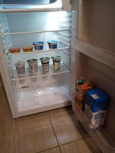 克拉皮納的住宿－Apartman 2，装有杯子和一盒牛奶的开放式冰箱