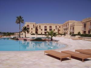 a resort with a swimming pool in front of a building at Fort Chambray Harbor Breeze in Għajnsielem