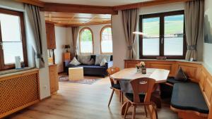 ein Wohnzimmer mit einem Tisch, Stühlen und einem Sofa in der Unterkunft Appartements Haus Olympia in Innsbruck