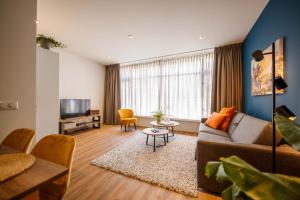 ein Wohnzimmer mit einem Sofa und einem TV in der Unterkunft Boutique Chic 55m2 Apartment with City Garden in ’s-Hertogenbosch