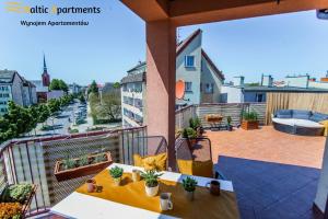 balkon ze stołem i krzesłami na budynku w obiekcie Baltic Apartments - Apartament Słoneczny Taras w Świnoujściu