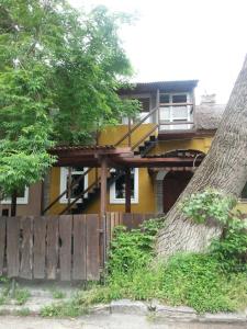 uma casa amarela com uma árvore em frente em Мини-гостиница em Kamianets-Podilskyi