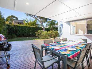 a table with chairs and a table cloth on a patio at Sapphire Sands - Pet Friendly - Community Pool in Callala Beach