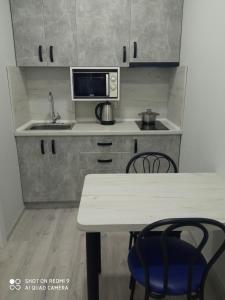 Нова і затишна квартира у центрі في أوجهورود: مطبخ صغير مع طاولة وميكروويف +10 صور
