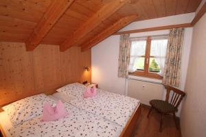 a bedroom with a bed and a chair and a window at Fewo Christina in Krün